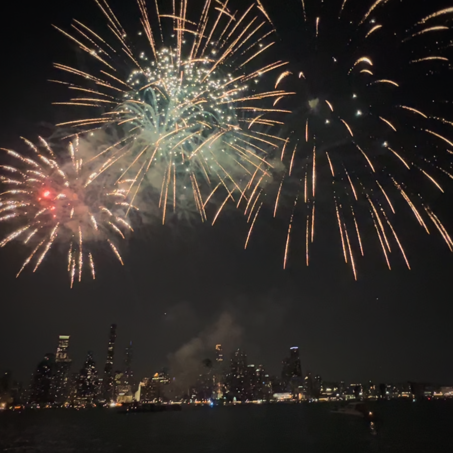 Fireworks explode over the Chicago skyline as viewed from a boat in Lake Michigan
